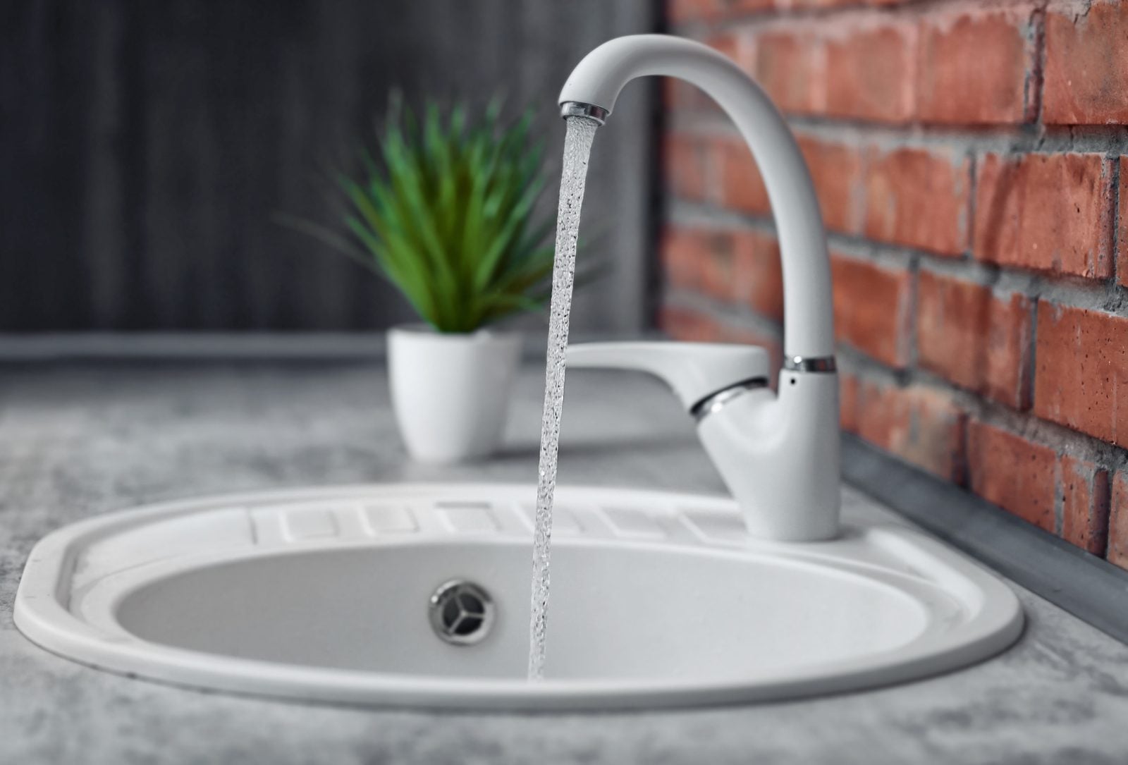 Water running from a faucet into a round sink